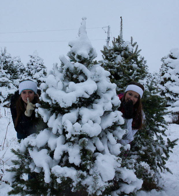 two teenage girls claiming a tree in the snow